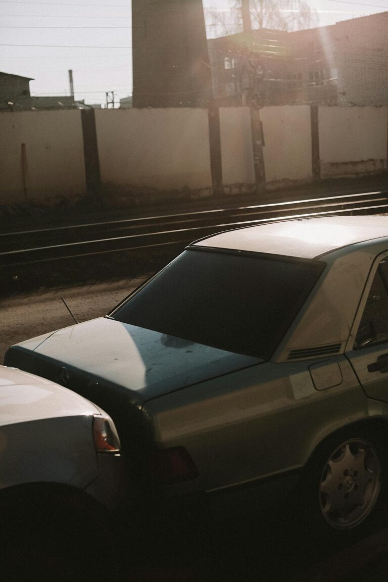 Close-up of two vehicles in a minor fender bender near railroad tracks.
