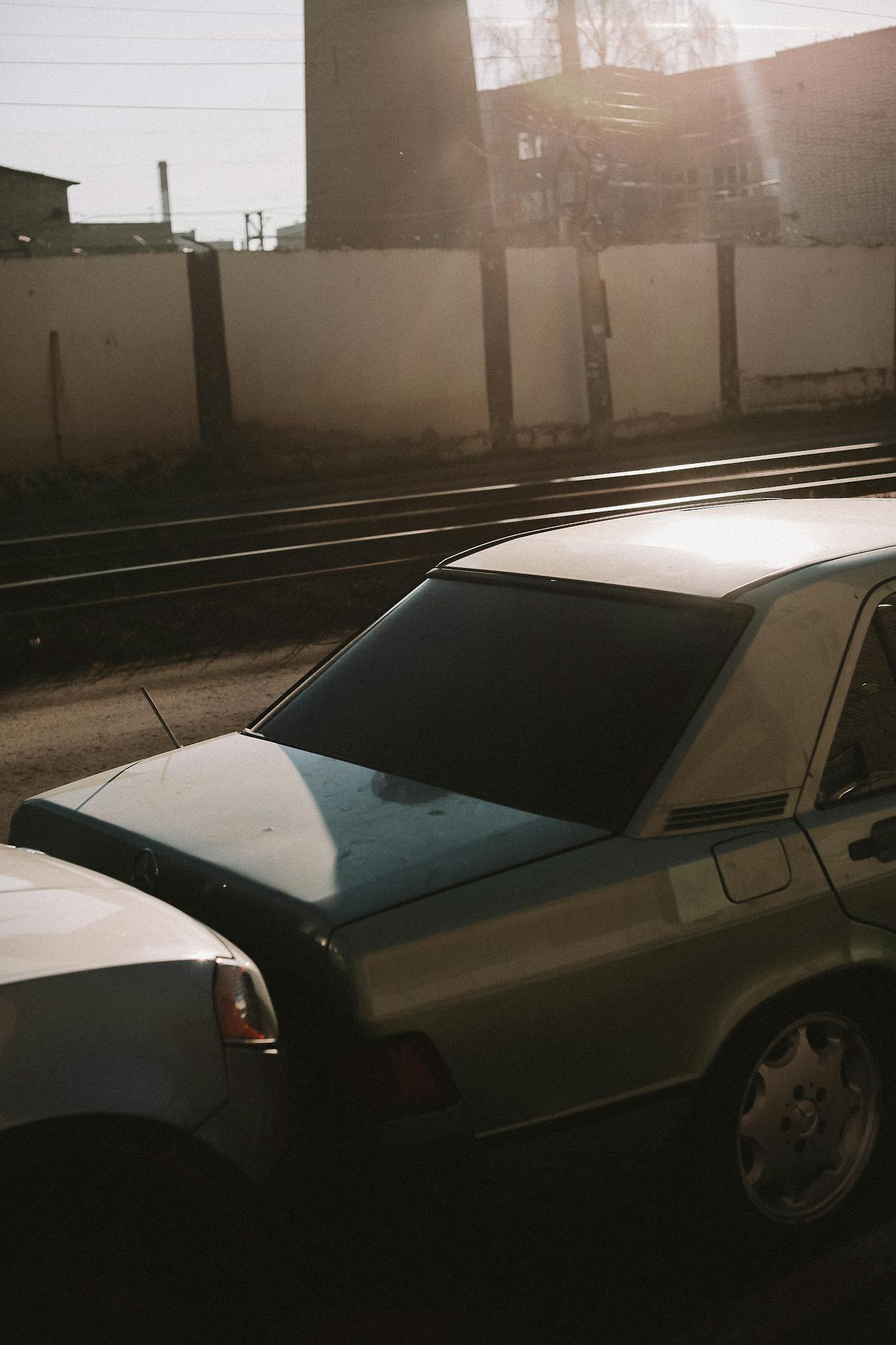 Close-up of two vehicles in a minor fender bender near railroad tracks.